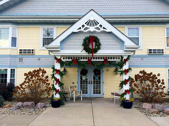 Yellow house decorated for Christmas by Designer Landscapes