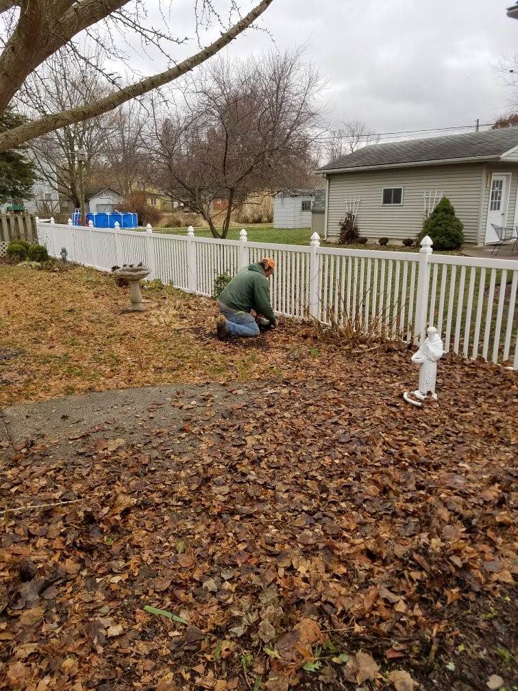 A photograph of a staffer cleaning up a landscape.