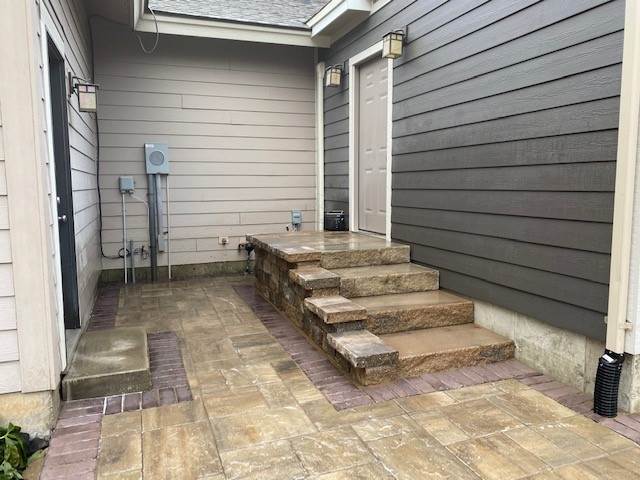photo of back door with stone steps and stone paver patio