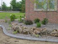 front yard with ornamental boulders and concrete edging